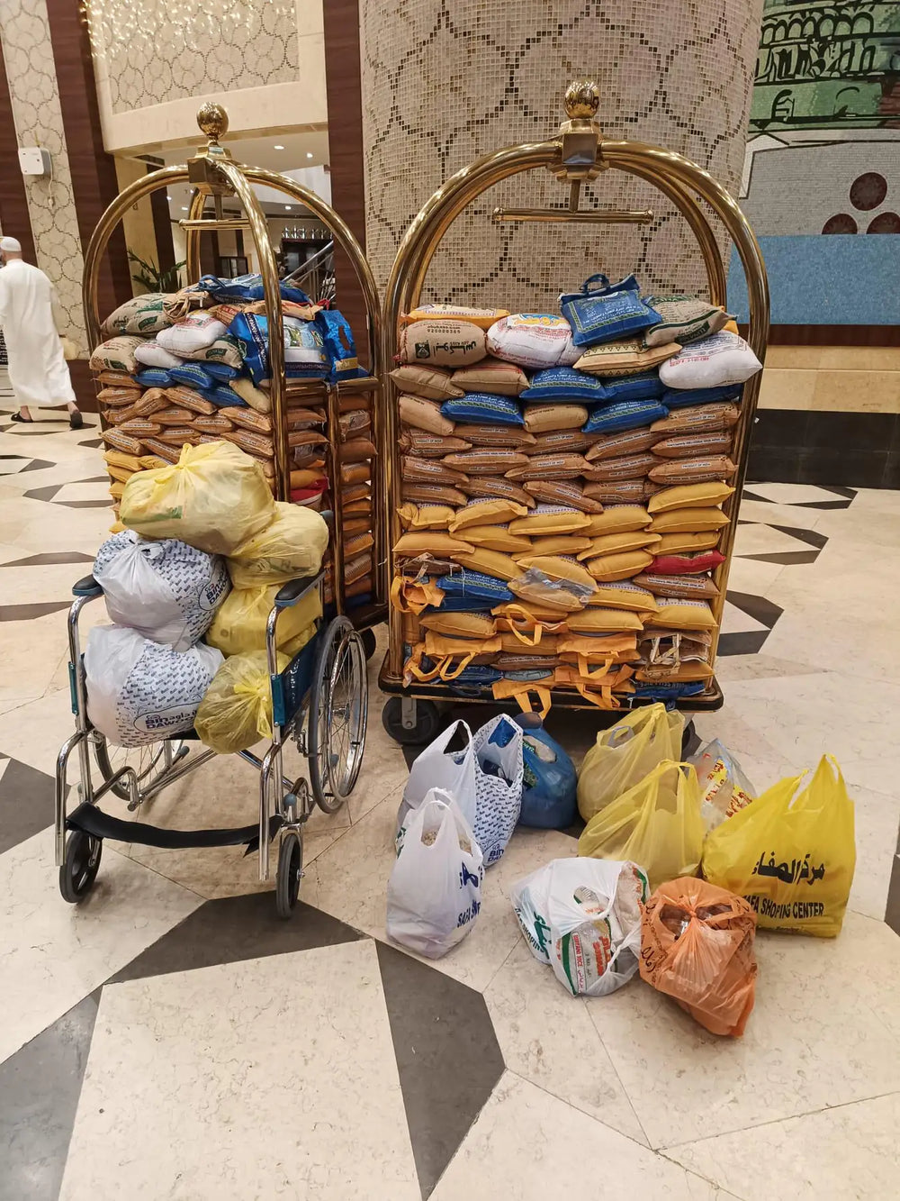 Sacs de denrées et fauteuil roulant sur des chariots dans un hall