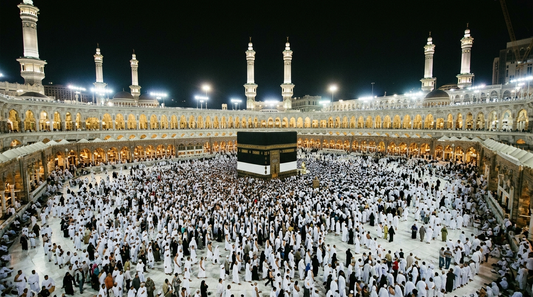 Grande Mosquée de La Mecque illuminée la nuit avec foule dense de pèlerins autour de la Kaaba