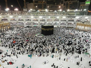 La Kaaba de nuit entourée de pèlerins