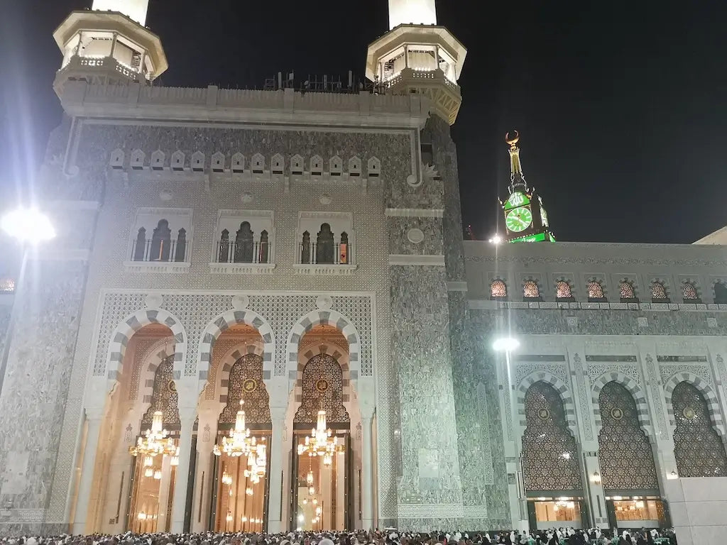 Large mosque with minarets and intricate architecture at night.