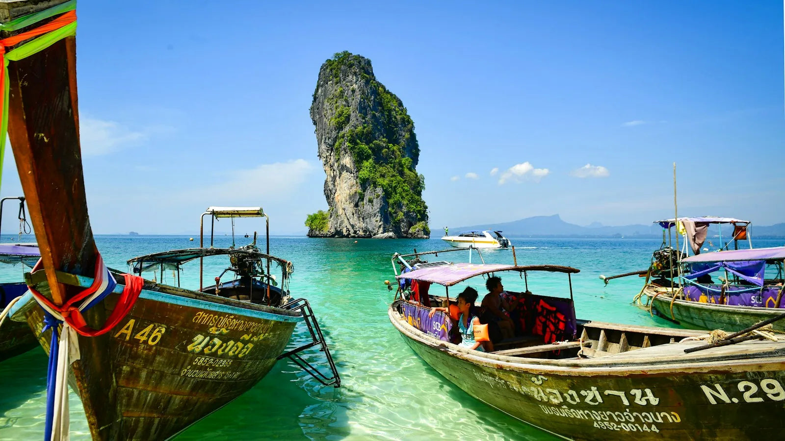 Bateaux traditionnels et reliefs calcaires dans les eaux de Krabi, en Thaïlande